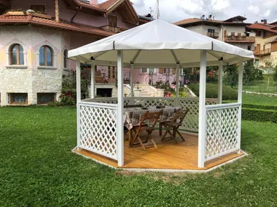 a gazebo with a table and chairs in a yard at Appartamento Rosa in Coredo