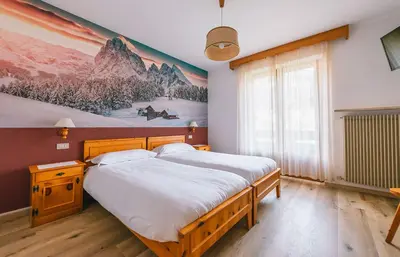 a garden with flowers and mountains in the background at Hotel Garnì Rosengarten in Pera
