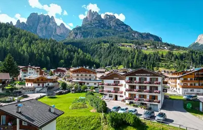 a village in the mountains with mountains in the background at Hotel Garnì Rosengarten in Pera