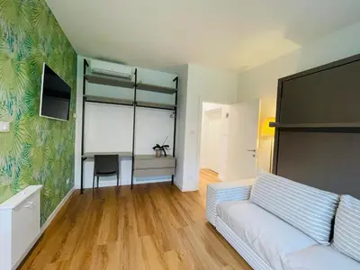 a living room with a white couch and a desk at Green View: il verde in città in Bolzano