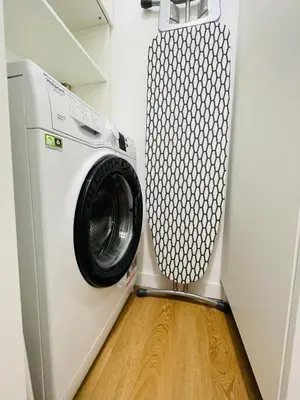 a washing machine in a laundry room with a wooden floor at Green View: il verde in città in Bolzano