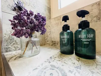 two bottles of soap and flowers on a counter at Green View: il verde in città in Bolzano