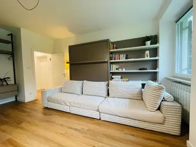a living room with a white couch with pillows at Green View: il verde in città in Bolzano