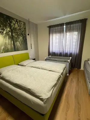a bedroom with two beds and a window at Green View: il verde in città in Bolzano