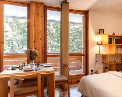 a bedroom with a bed and a table and chairs at Loft a Canazei vicino alle piste vista Marmolada in Alba di Canazei