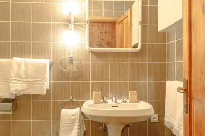 a bathroom with a sink and a mirror and towels at Loft a Canazei vicino alle piste vista Marmolada in Alba di Canazei