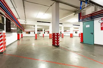 a large empty parking garage with red and white columns at Loft a Canazei vicino alle piste vista Marmolada in Alba di Canazei