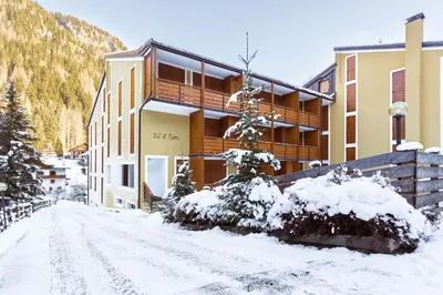 a snow covered street in front of a building at Loft a Canazei vicino alle piste vista Marmolada in Alba di Canazei