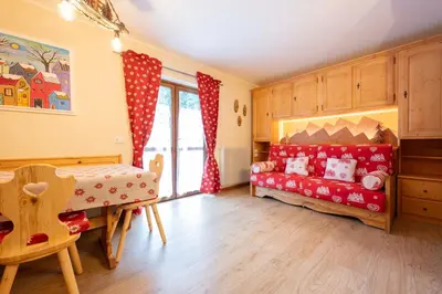 a childs room with a red couch and a table at Cesa Ariale in Canazei