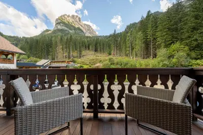 a balcony with two chairs and a view of a mountain at Cesa Ariale in Canazei