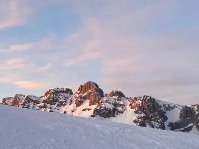 a snow covered mountain with rocks in the background at Il nido dei gufi in Falcade