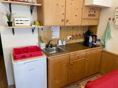 a small kitchen with a sink and a dishwasher at Il nido dei gufi in Falcade