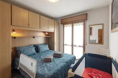 a bedroom with a blue bed and a chair at Dolomitihouse VIEGHEL in Fiera di Primiero