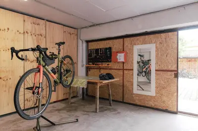 a bike is hanging on a wall next to a table at Dolomitihouse VIEGHEL in Fiera di Primiero