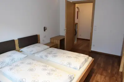 a bedroom with two beds and a hallway at Haus Fulterer in Siusi