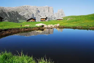 a lake in front of a mountain with a house at Haus Fulterer in Siusi
