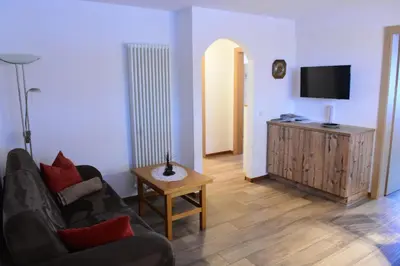 a living room with a couch and a tv at Haus Fulterer in Siusi