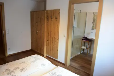 a bedroom with a bed and a glass shower at Haus Fulterer in Siusi