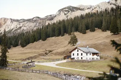 a house on the side of a mountain with a road at Rifugio Malga Ra Stua in Cortina dʼAmpezzo