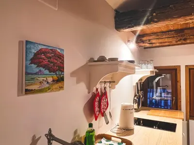 a kitchen with a red tree painting on the wall at Holy View Apartment in Bolzano