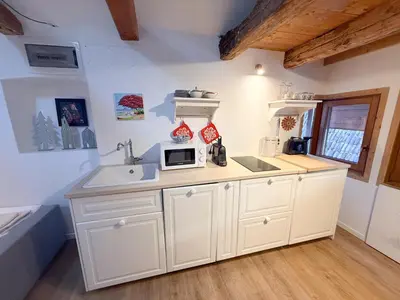 a white kitchen with a sink and a microwave at Holy View Apartment in Bolzano