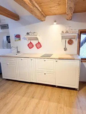 a kitchen with white cabinets and a sink at Holy View Apartment in Bolzano