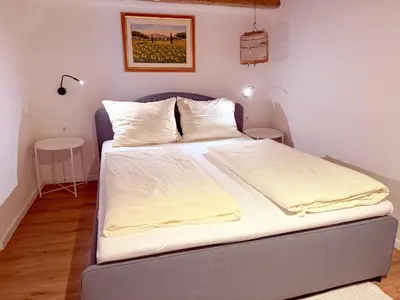a bed with white sheets and pillows in a room at Holy View Apartment in Bolzano