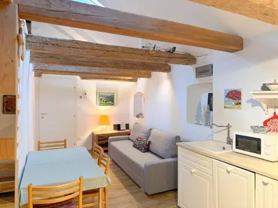 a kitchen and living room with a couch and a table at Holy View Apartment in Bolzano