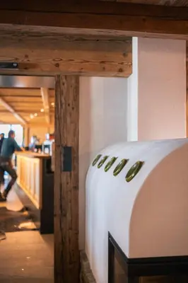 a table in a restaurant with a counter and a person at Starkenfeldhütte in Rodengo