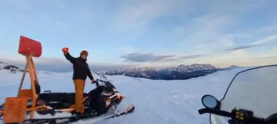 a person standing on top of a snowmobile in the snow at Starkenfeldhütte in Rodengo