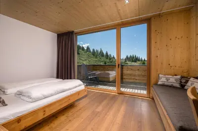 a bedroom with a bed and a large window at Starkenfeldhütte in Rodengo