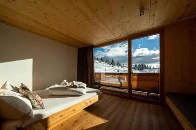 a bedroom with a bed and a large window at Starkenfeldhütte in Rodengo