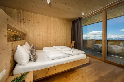 a bed in a room with a large window at Starkenfeldhütte in Rodengo