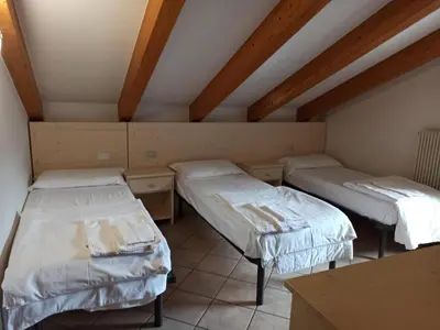two beds in a room with wooden ceilings at Villa San Carlo in Pozza di Fassa