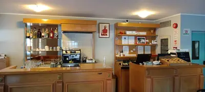 a bar with wooden cabinets and a counter with alcohol at Villa San Carlo in Pozza di Fassa