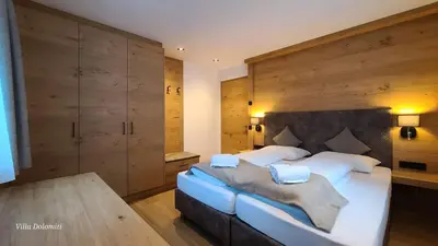 a bedroom with a large bed with wooden walls at Villa Dolomiti in Ortisei