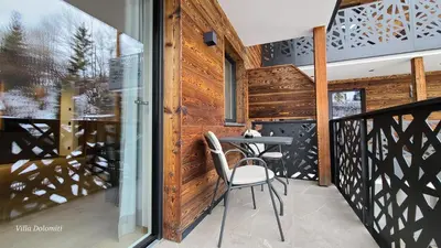 a balcony of a house with a table and chairs at Villa Dolomiti in Ortisei