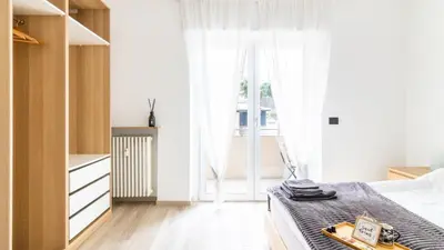 a bedroom with a bed and a large window at Cloudberry Home in Merano
