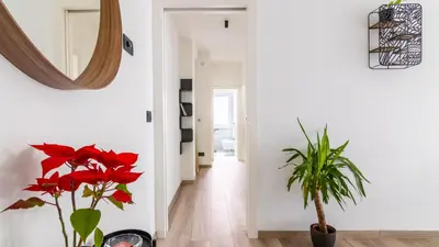 a hallway with red flowers and a mirror at Cloudberry Home in Merano