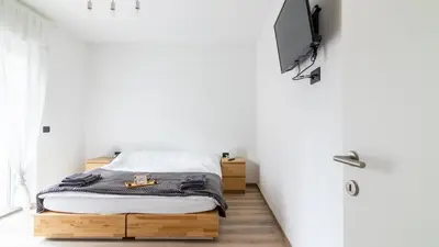 a bedroom with a bed and a tv on the wall at Cloudberry Home in Merano