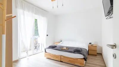 a bedroom with a bed and a large window at Cloudberry Home in Merano