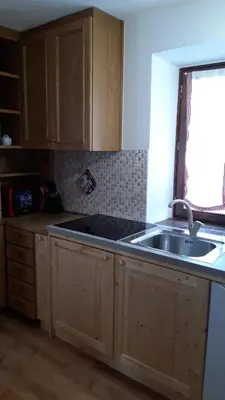 a kitchen with wooden cabinets and a sink and a window at CasaMau Bilo in Pera