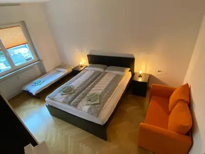 a small bedroom with a bed and a couch at Appartamento del CONTE a Merano, con piscina, leggere attentamente le info o chiamare direttamente l'host! in Merano