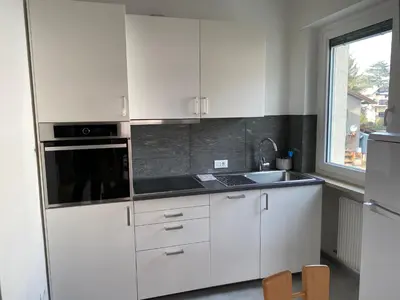 a kitchen with white cabinets and a sink and a window at Appartamento del CONTE a Merano, con piscina, leggere attentamente le info o chiamare direttamente l'host! in Merano