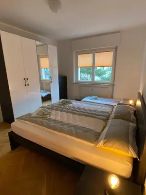 a large bed in a bedroom with two windows at Appartamento del CONTE a Merano, con piscina, leggere attentamente le info o chiamare direttamente l'host! in Merano