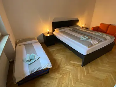 a bedroom with two beds and a couch at Appartamento del CONTE a Merano, con piscina, leggere attentamente le info o chiamare direttamente l'host! in Merano
