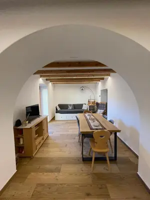 a dining room with a table and a bed at Appartamento Gioia di Bosco in Carano