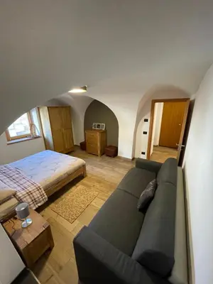 a living room with a couch and a bed at Appartamento Gioia di Bosco in Carano