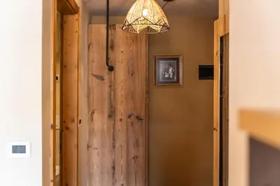 a large wooden door in a hallway with a chandelier at Ciasa Buro - Zen in Moena
