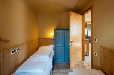 a room with two beds and a blue cabinet at Ciasa Buro - Zen in Moena
